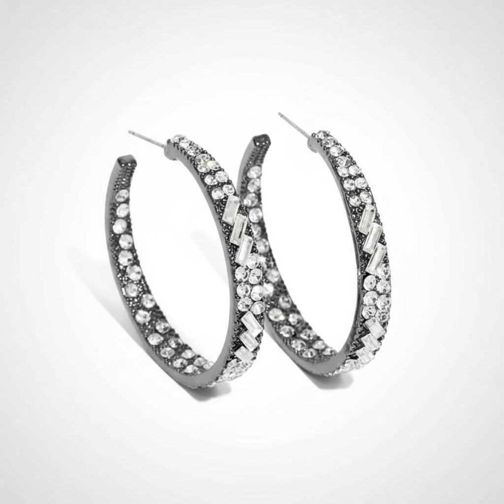 Pair of silver hoop earrings with clear gemstones on a white background