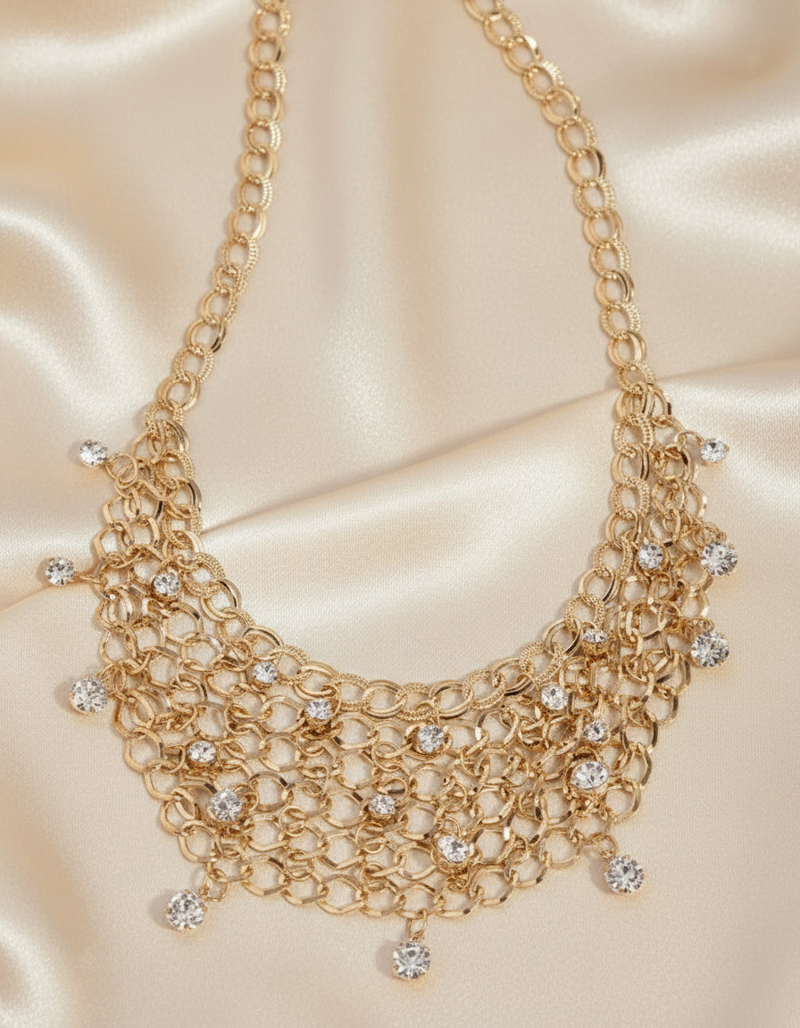 Gold chain necklace with small round embellishments on a white background