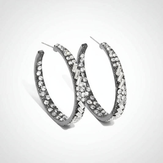 Pair of silver hoop earrings with clear gemstones on a white background
