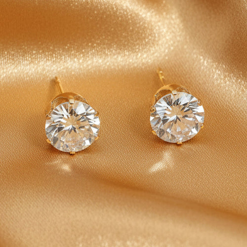 Gold stud earrings with clear gemstones on a white background