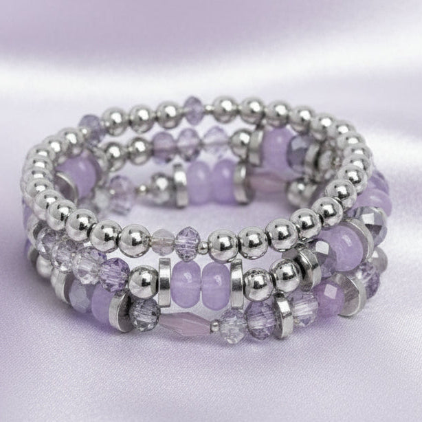 Stack of purple and silver beaded bracelets on a white background