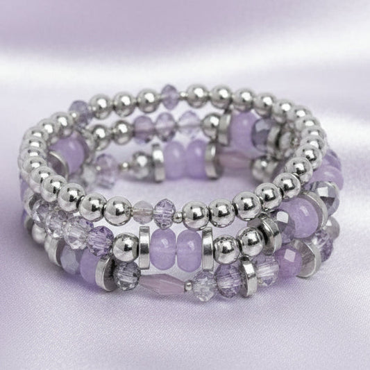 Stack of purple and silver beaded bracelets on a white background