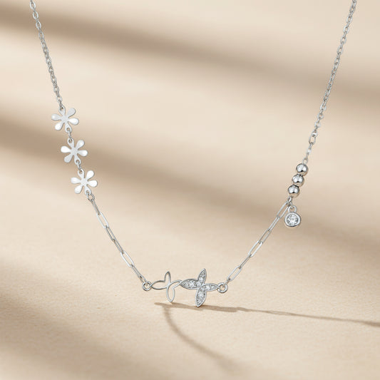 Silver necklace with floral and butterfly designs on a light gray background